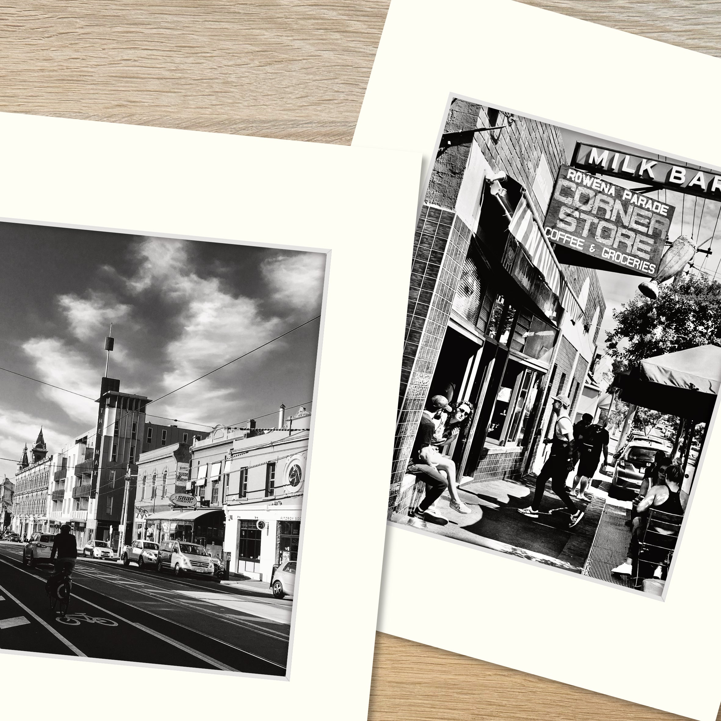 Two frame mounts, one containing a b&w print of urban street scene and another, a b&w print of outside cafe scene