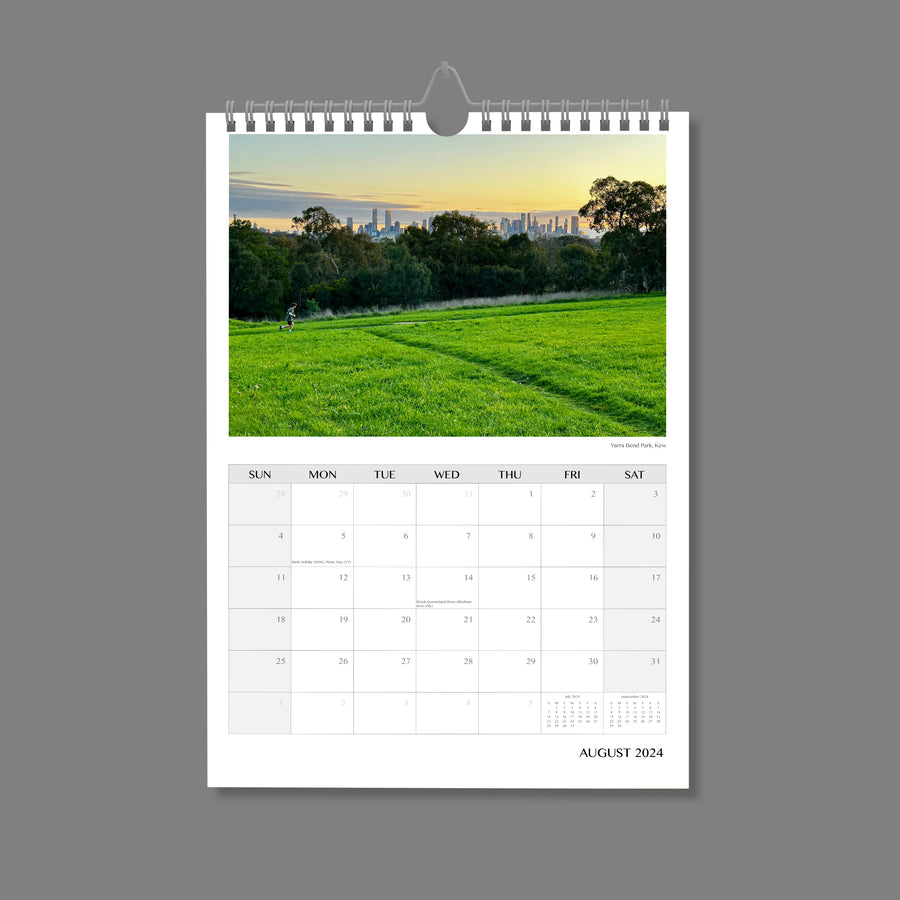 A4 Wall Calendar: Marvellous Melbourne featuring a lone runner with green grass in foreground and city skyline in distance