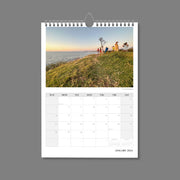 A4 Wall Calendar: Marvellous Melbourne featuring people on top of a grassed hill looking out to the bay at sunset