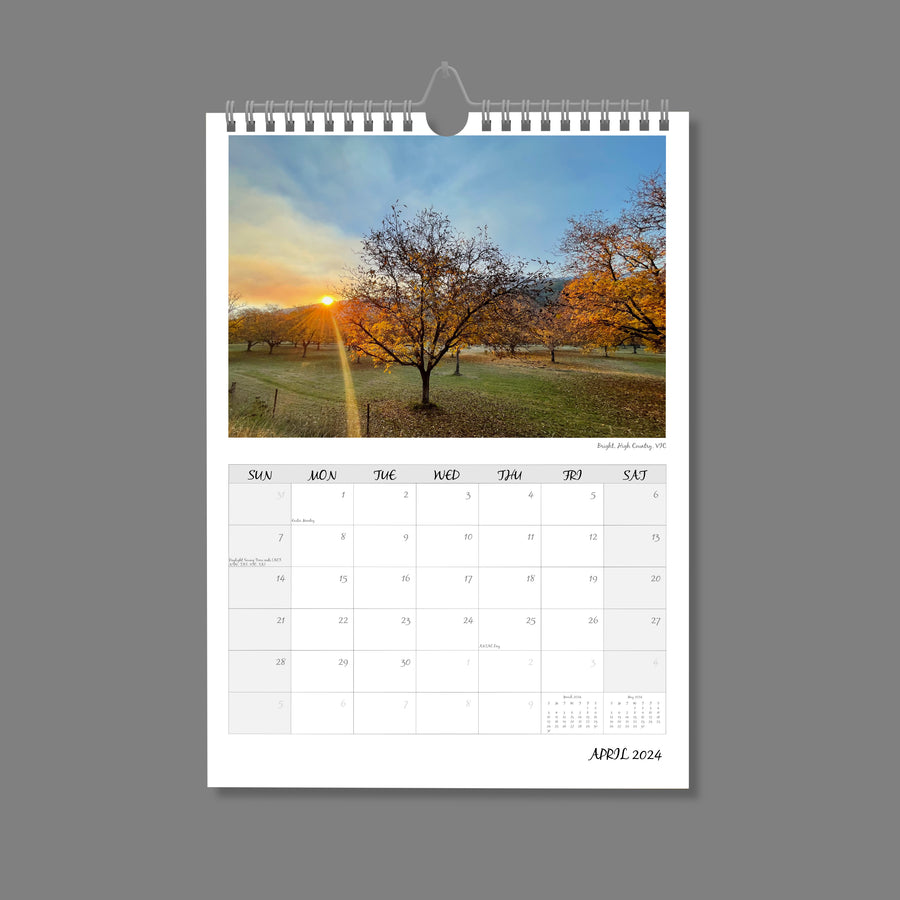 A4 Wall Calendar: Golden Hour featuring an orchard of tress tipped in golden light as the sun is setting in the distance