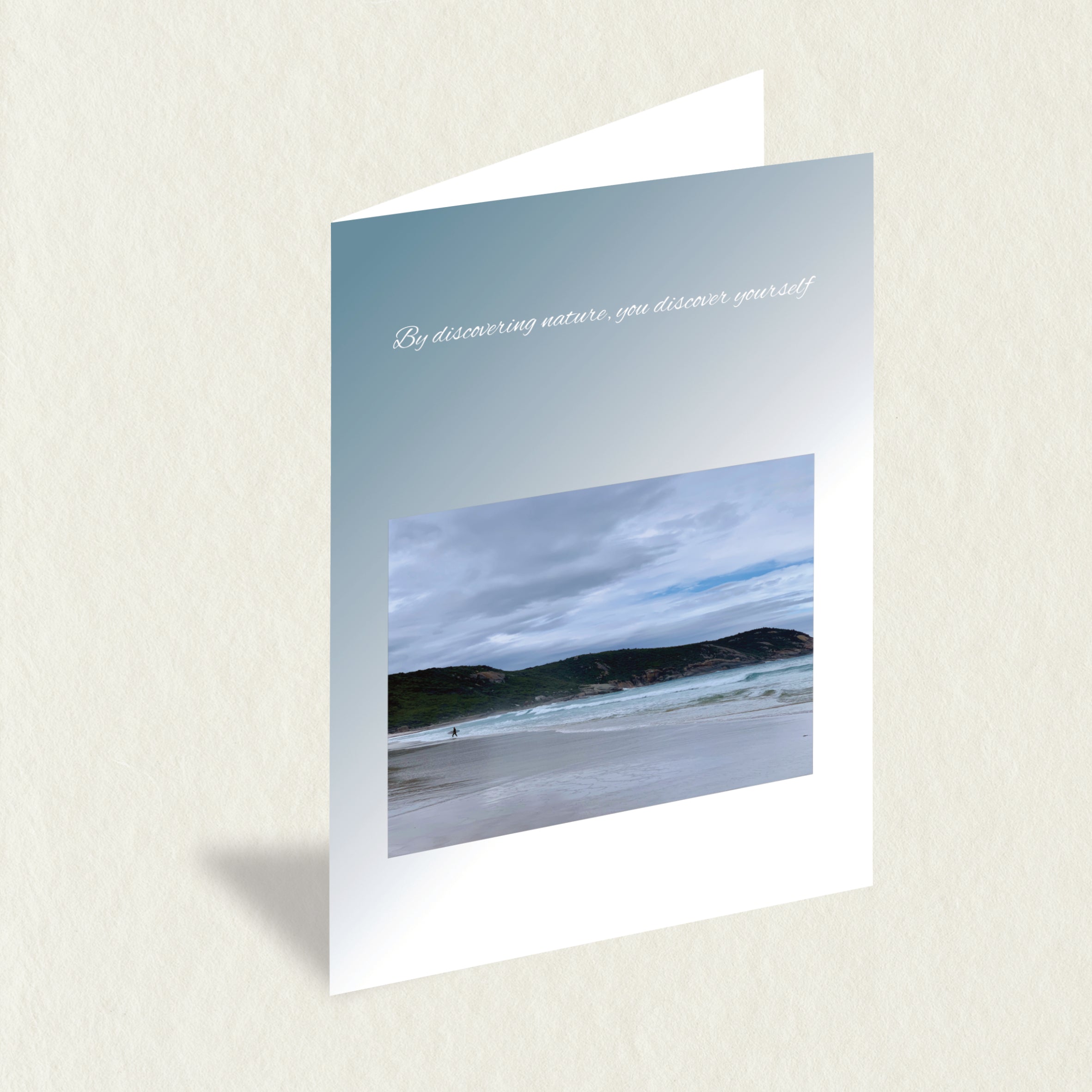 Designer Greeting Card: Lone Surfer featuring a lone surfer on the beach on a cool, grey day and a nature quote to complement