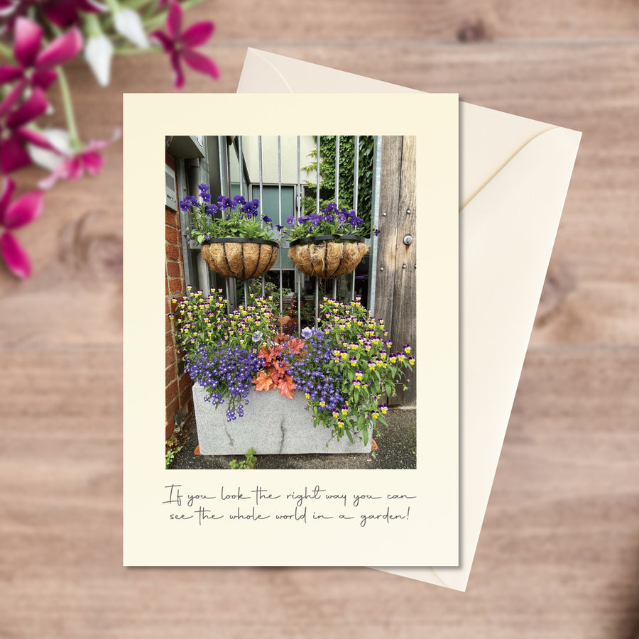 A6 greeting card of a tiny but cheerful apartment garden  overflowing with flowers, in flat-lay with envelope 