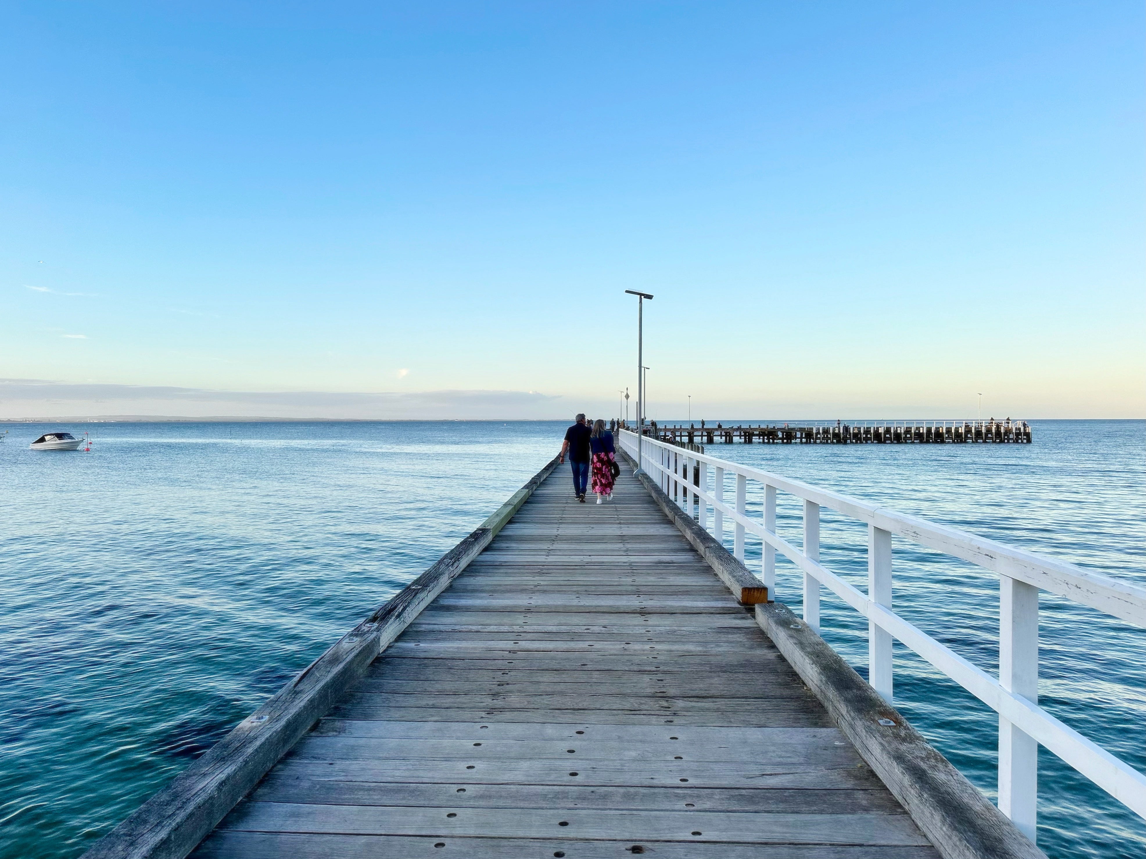 the pier extending forward into the bay with soft blue tones of evening light