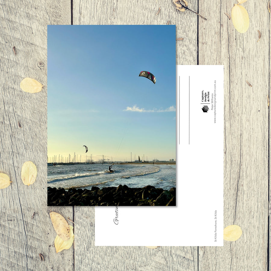 Postcard from Melbourne: Kite Surfers, a kite surfer riding the waves on the foreshore at twilight with another kite in the distance