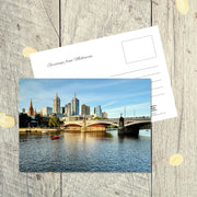 Postcard from Melbourne: Princes Bridge, a landscape postcard featuring the bridge reflecting in the river and sun tipped buildings beyond