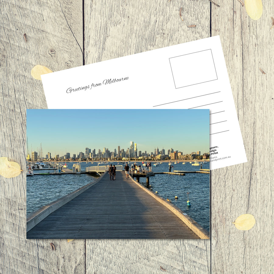 Postcard from Melbourne: St Kilda Pier, a landscape postcard featuring the pier looking north across the water to the skyline