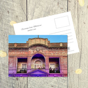 Postcard from Melbourne: Another View, featuring young people on the balcony of an old theatre which is illuminated in purple hues 