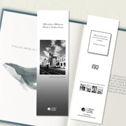 A two sided 200 x 60 bookmark displayed inside a book, featuring an urban street in classic B&W with grey background variant