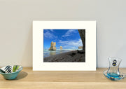 Frame mount containing a colour print of lofty rock formations jutting out of the ocean upright on sideboard