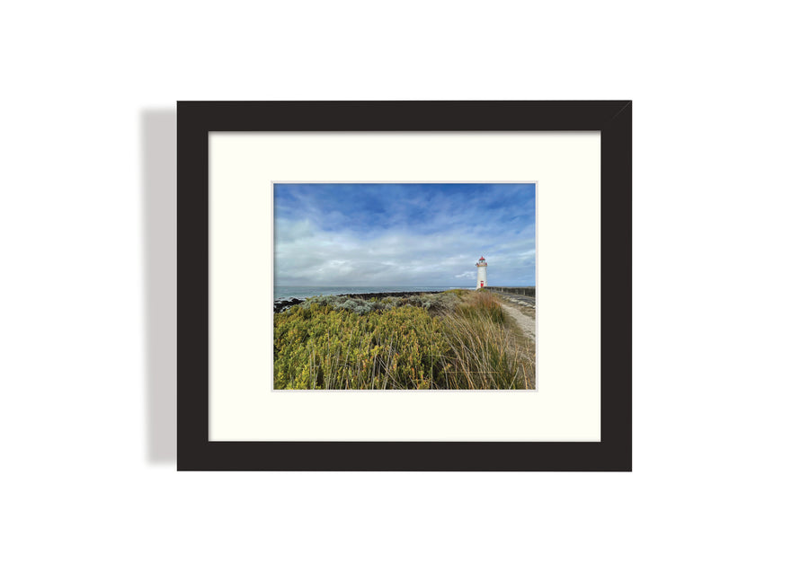 Frame mount with print of lighthouse and grassland in finalised picture frame hanging on wall