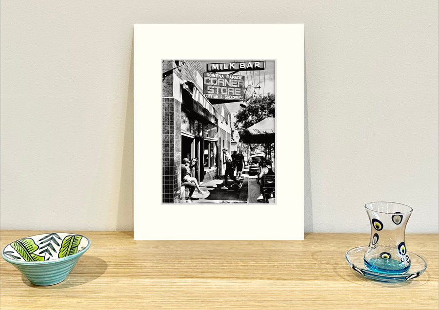 Frame mount containing a B&W print of a cool cafe in Richmond sitting upright on sideboard with objets d’art to the sides