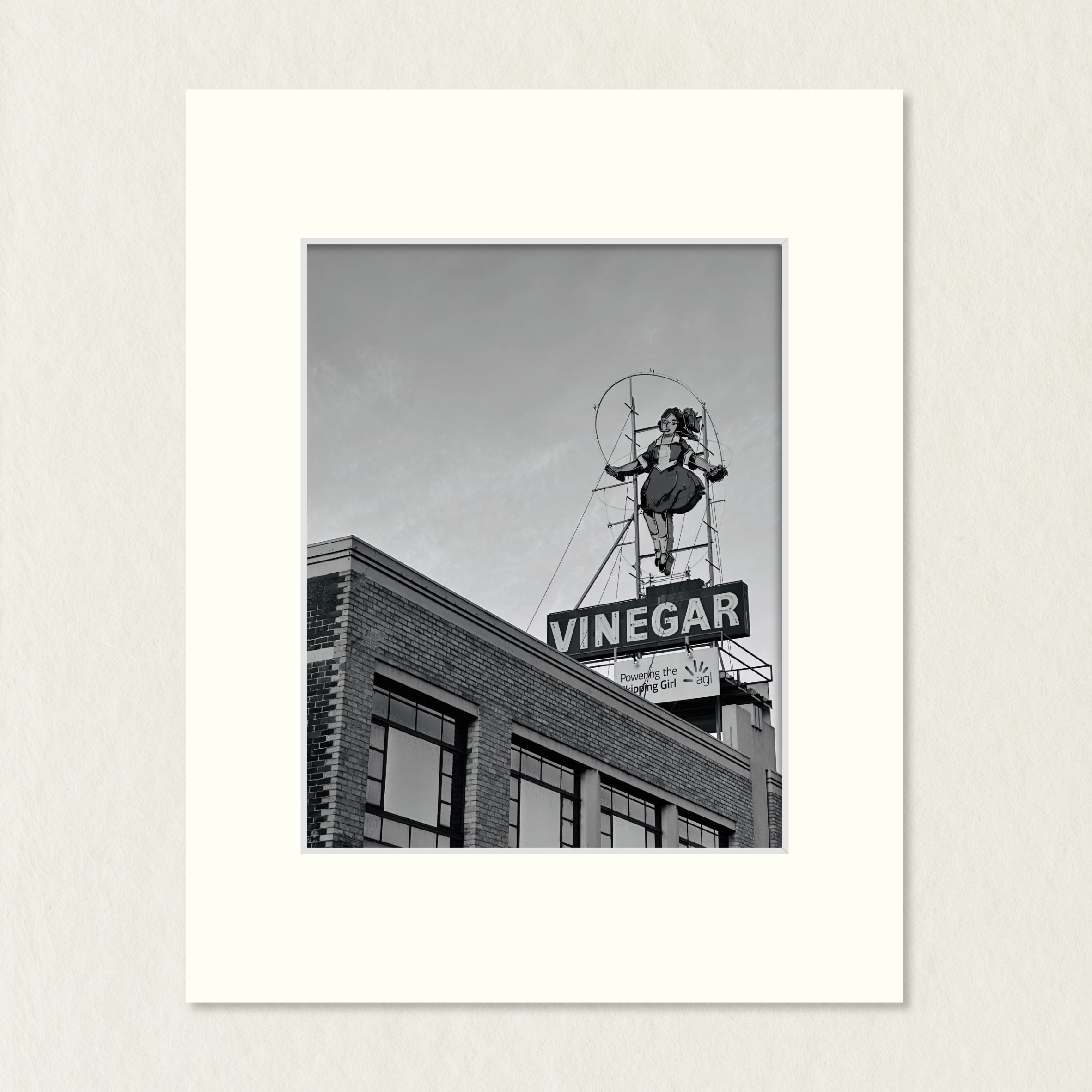 Ready to Frame Print: Skipping Girl - frame mount containing a B&W print of the landmark skipping girl sign atop a Melbourne factory